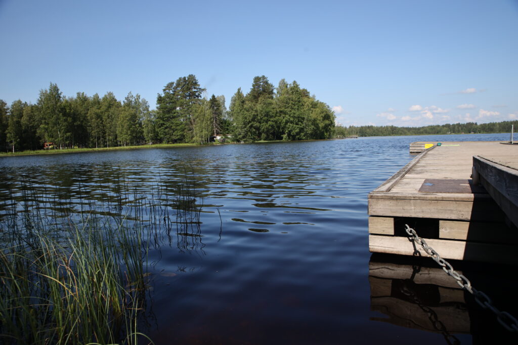 Järvimaisema, jossa näkyy laituria ja takana olevaa metsää.